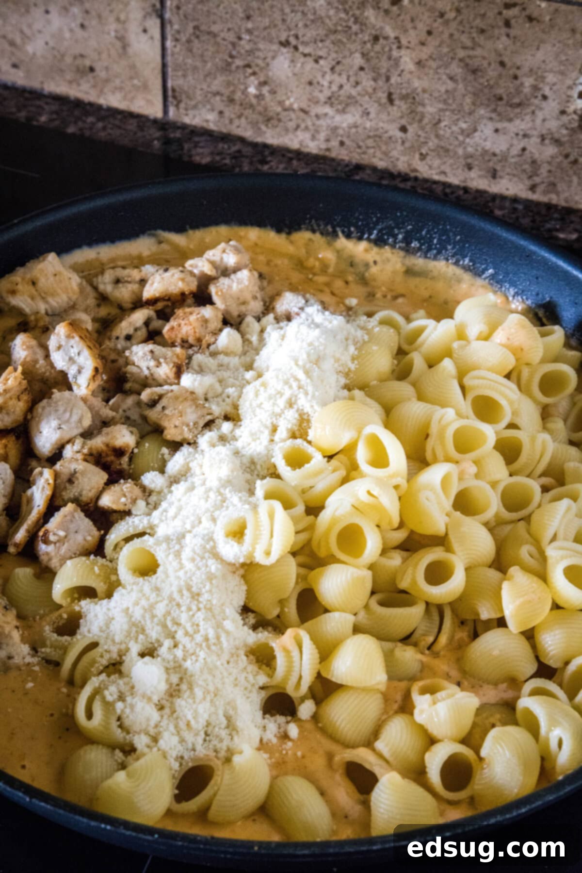 Flavor-packed Marry Me Chicken pasta is a 30-minute, one-pan weeknight dinner with tender pasta and chicken in creamy sun-dried tomato sauce. Pasta, cubed chicken, and parmesan cheese added to sun-dried tomato sauce in a skillet.