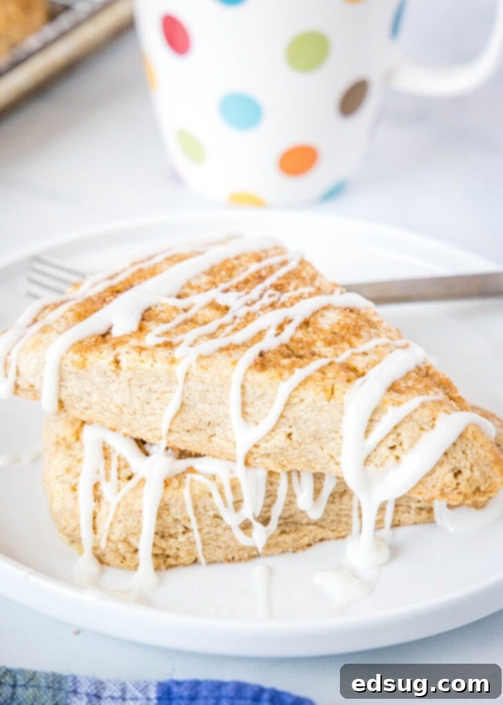 stacked cinnamon scones with icing on a white plate