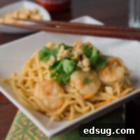 Easy One-Pot Thai Shrimp Pasta 3 shrimp pasta in a white bowl topped with cilantro and peanuts