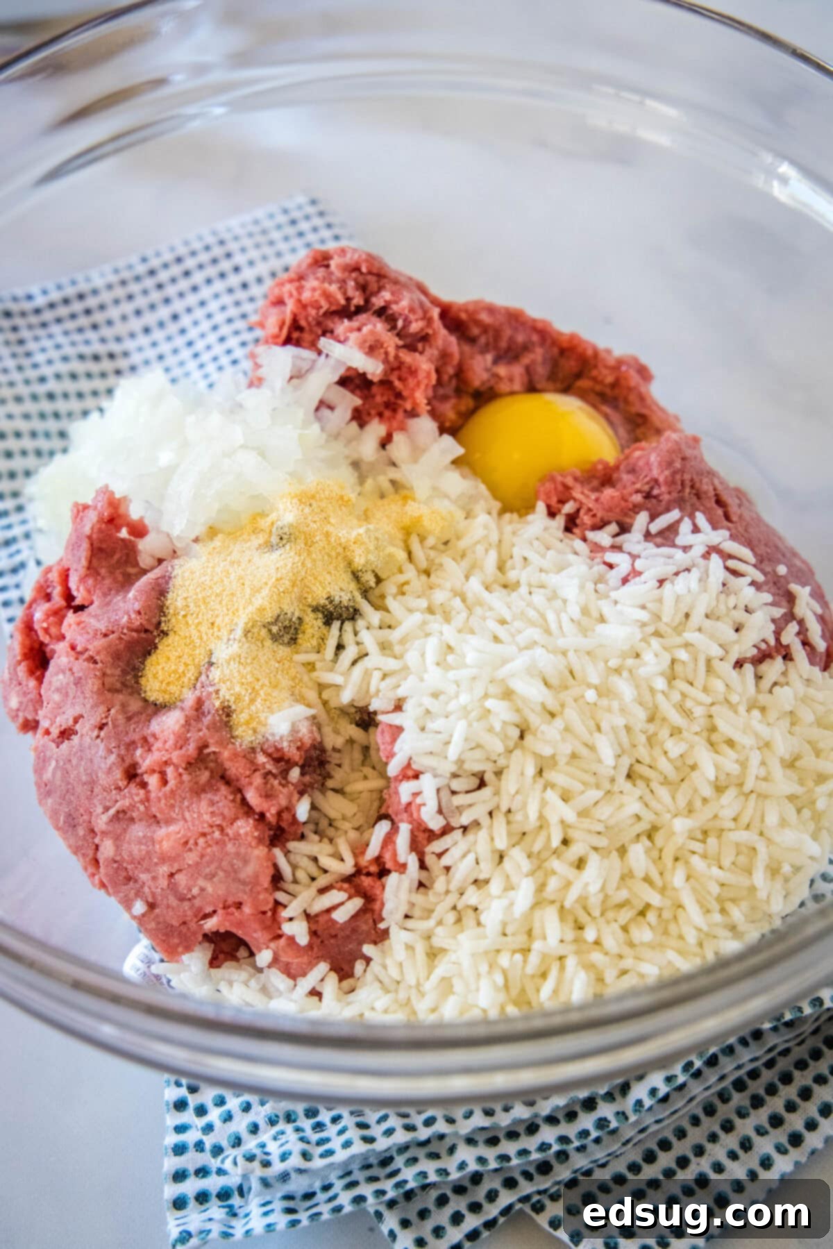Meatball ingredients combined in a glass bowl.