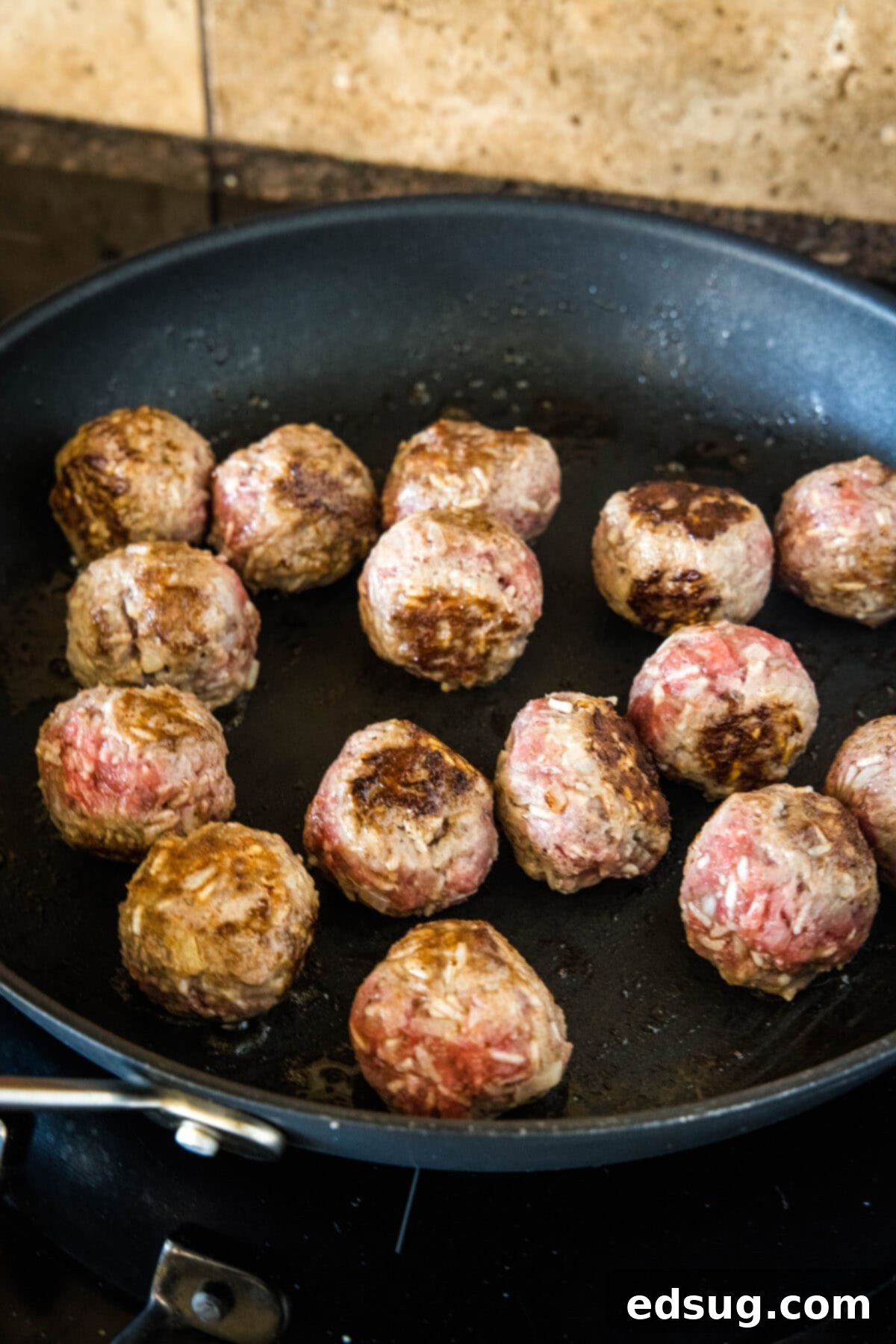 Porcupine meatballs browning in a skillet.
