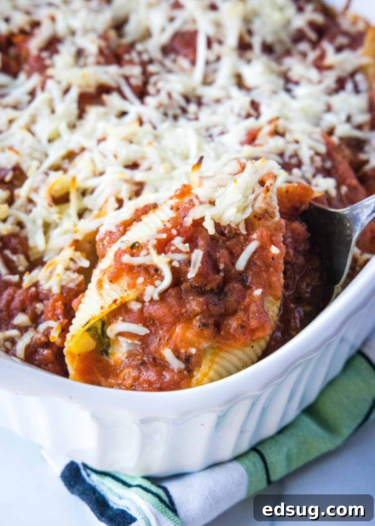 scooping stuffed shells out of baking dish