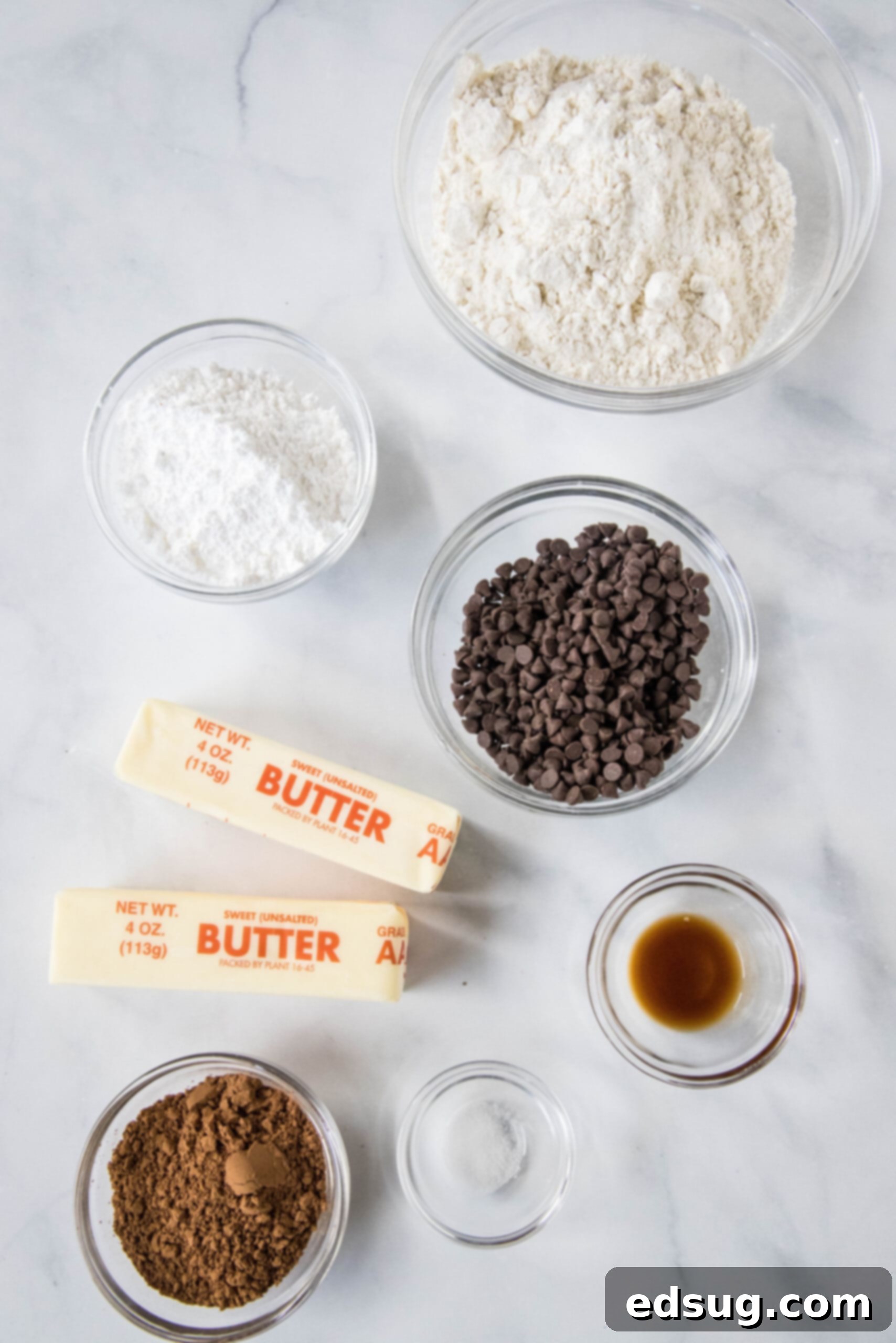 Chocolate snowball cookies are a fun twist on Mexican wedding cookies! These soft chocolate cookies are quick to make and irresistibly fudgy. A collection of ingredients for chocolate snowball cookies including butter, powdered sugar, cocoa powder, vanilla, flour, salt, and chocolate chips.