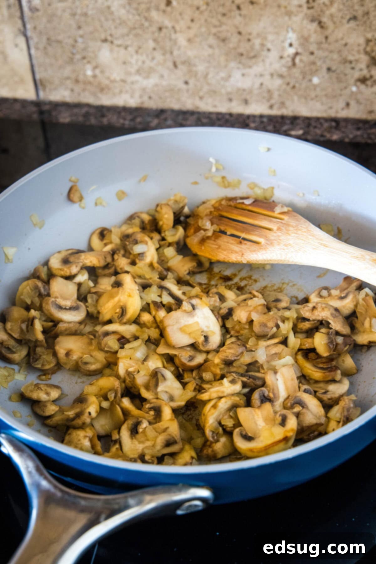 This chicken wild rice casserole is a hearty dinner loaded with juicy chicken, mushrooms, and nutty wild rice wrapped in creamy white sauce. Sauteed mushrooms in. skillet with a wooden spoon.