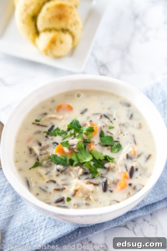A large pot of creamy chicken wild rice soup simmering on the stove.