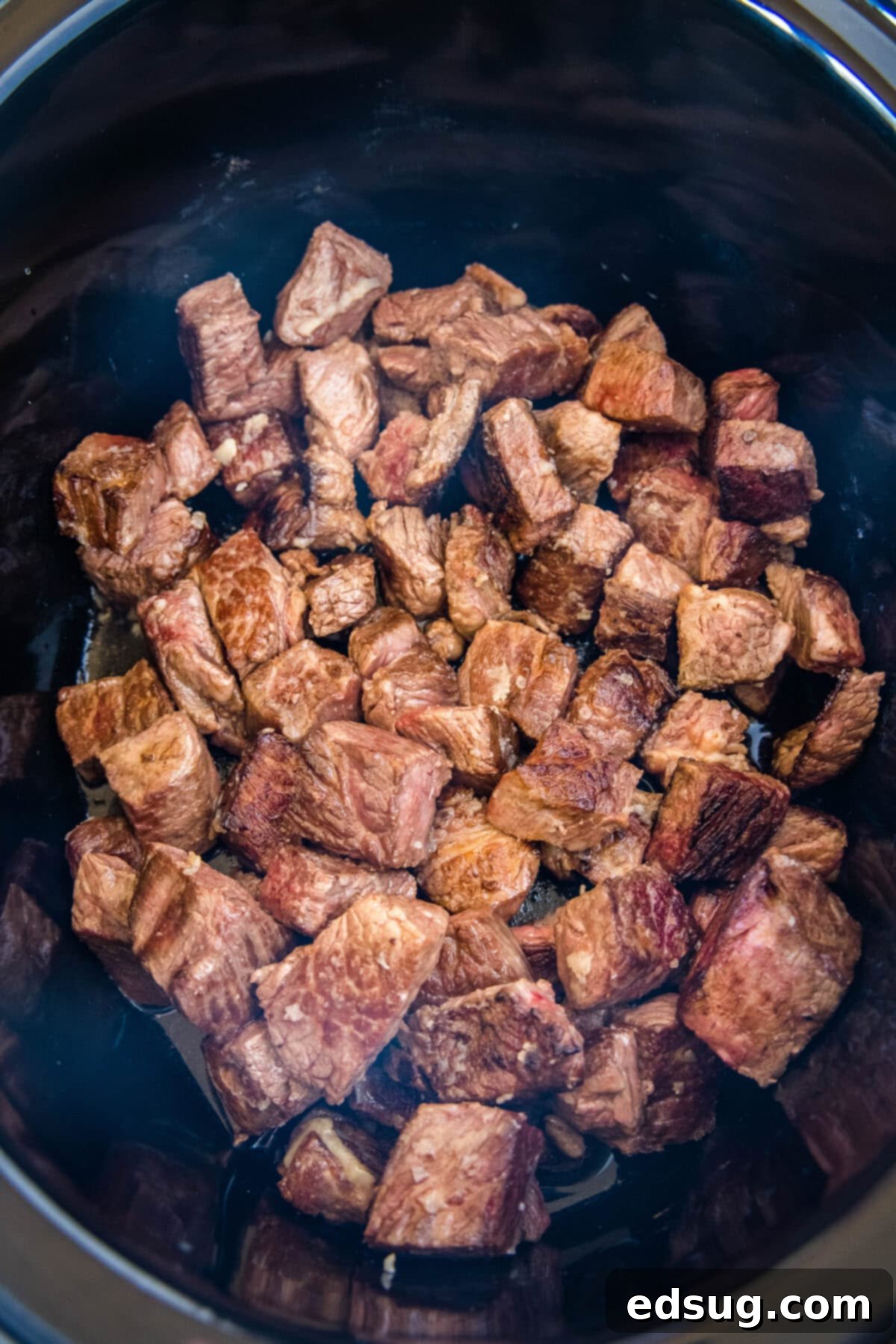 Seared steak bites inside the crockpot.