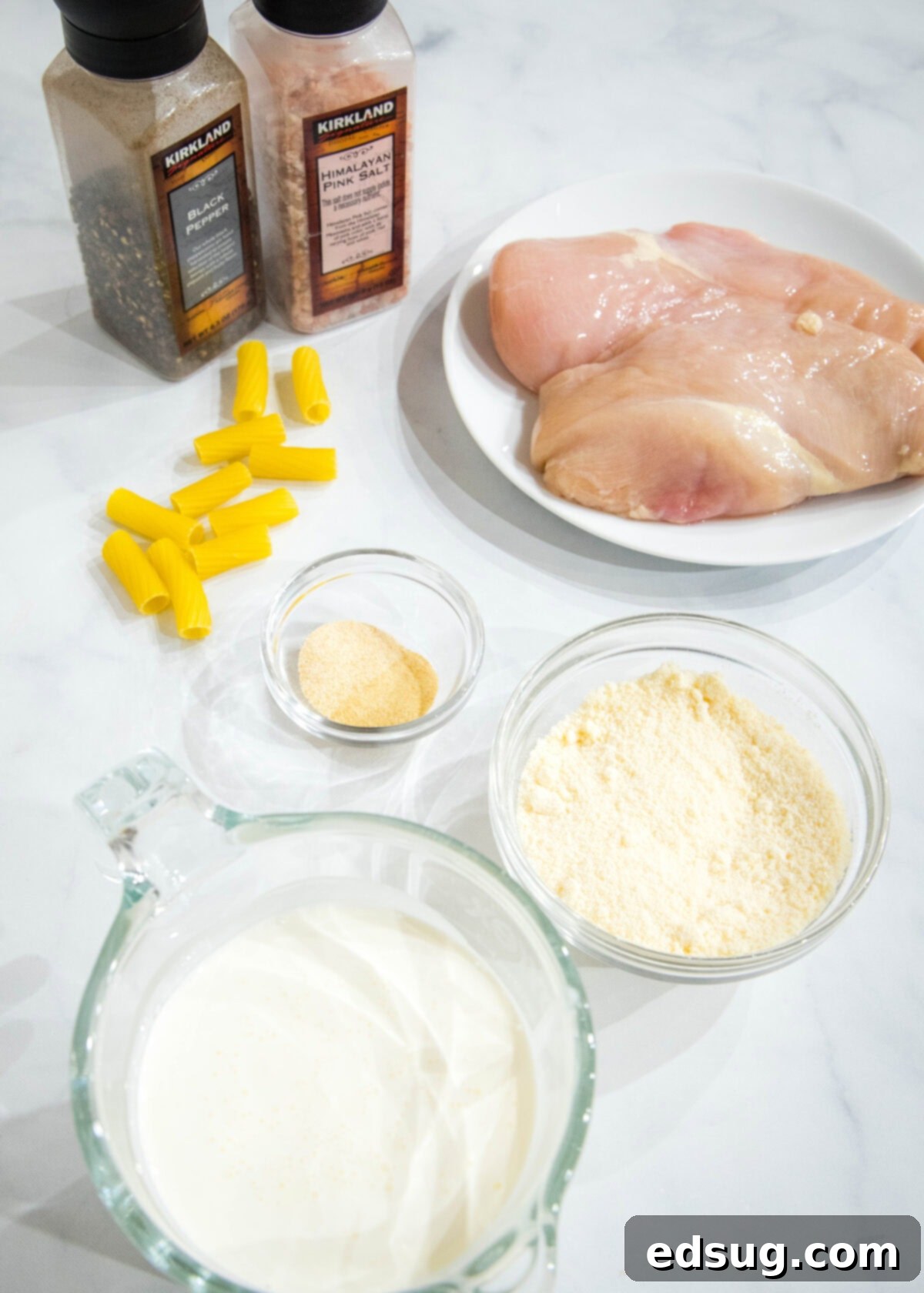 Crock pot chicken alfredo ingredients laid out on a cutting board.