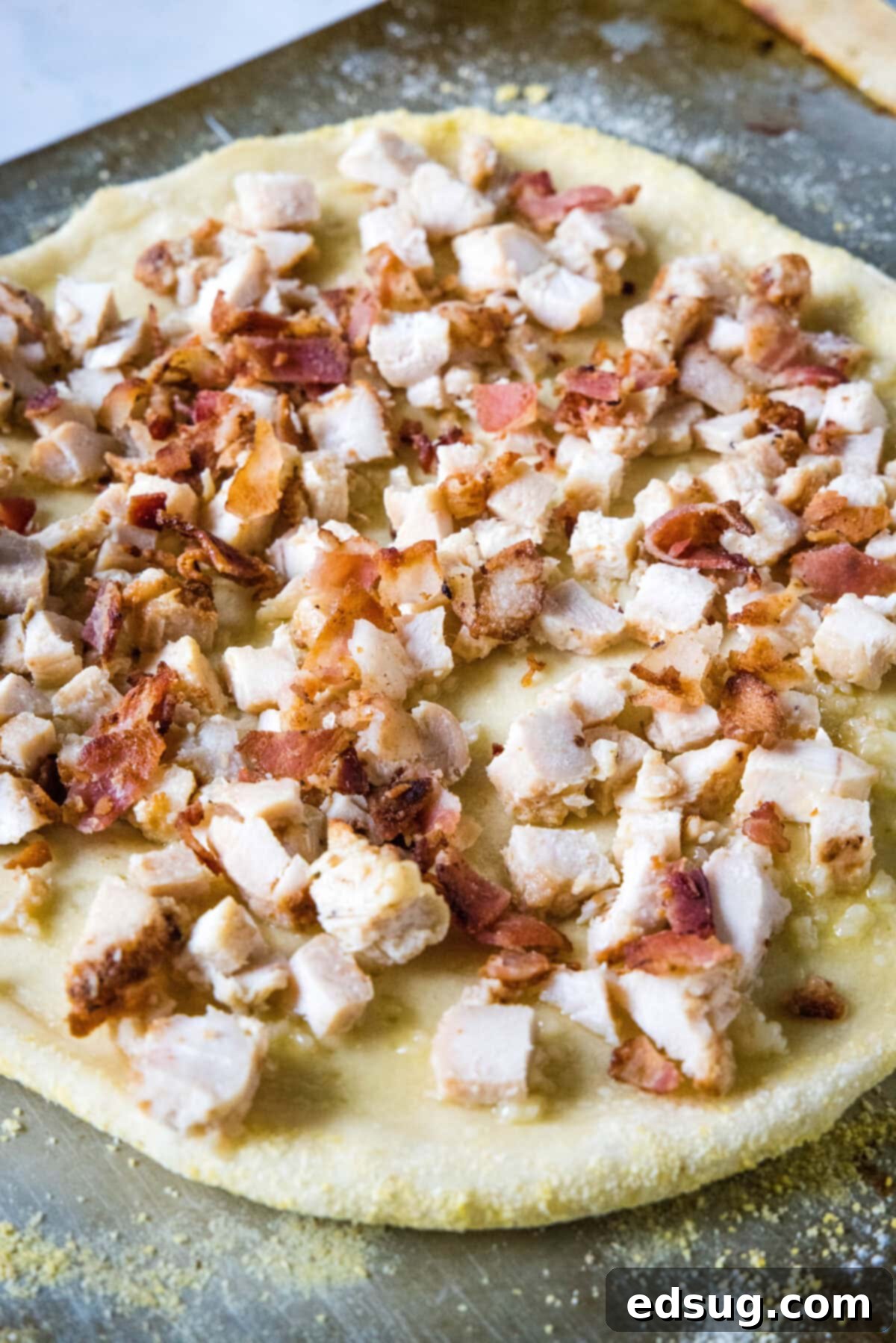 adding chicken and bacon over crust