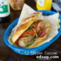 chicken sausage sandwich on a pretzel roll on a plate