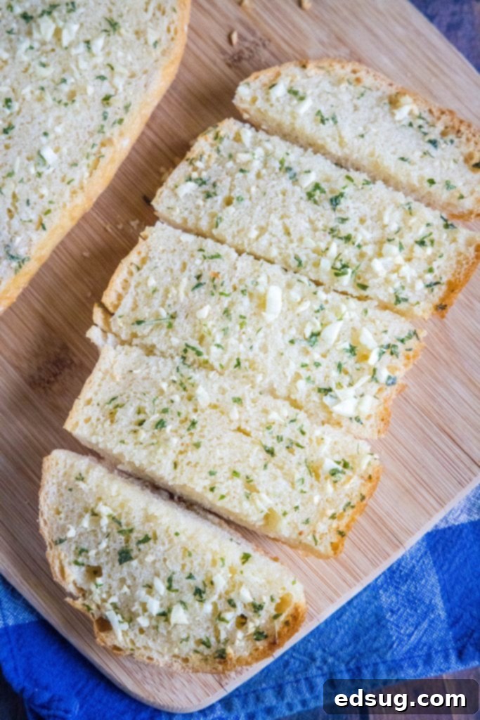 Buttery Garlic Bliss 2 sliced garlic bread on a cutting board, golden brown and garnished with fresh parsley