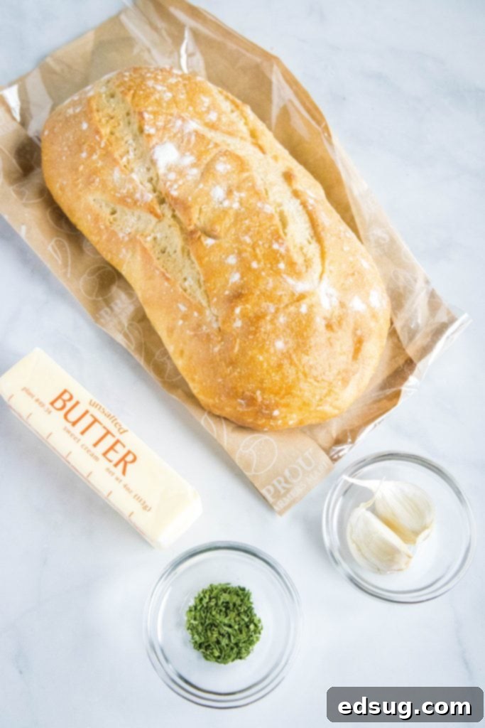 Buttery Garlic Bliss 3 fresh garlic bread ingredients including a loaf of bread, softened butter, garlic cloves, and fresh parsley
