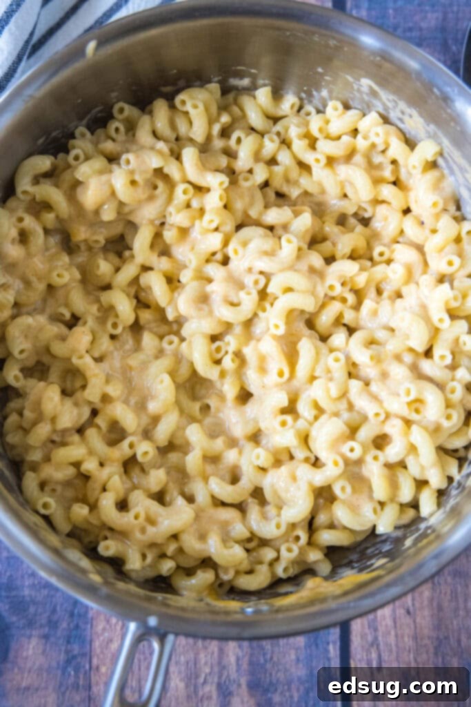 Freshly cooked elbow macaroni, awaiting the protein-rich Greek yogurt and gooey melted cheese for a healthy and delicious stovetop mac and cheese. A pot full of perfectly cooked elbow macaroni, freshly drained and ready for the cheese sauce.