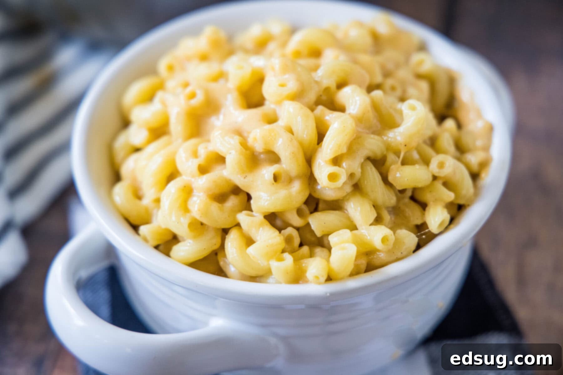 A tempting bowl of easy and healthy mac and cheese on the stovetop, featuring protein-rich Greek yogurt, gooey melted cheese, and spicy seasonings, ready to be enjoyed. A close-up of a serving of healthy mac and cheese, showing its rich, golden-brown cheese and perfect texture.