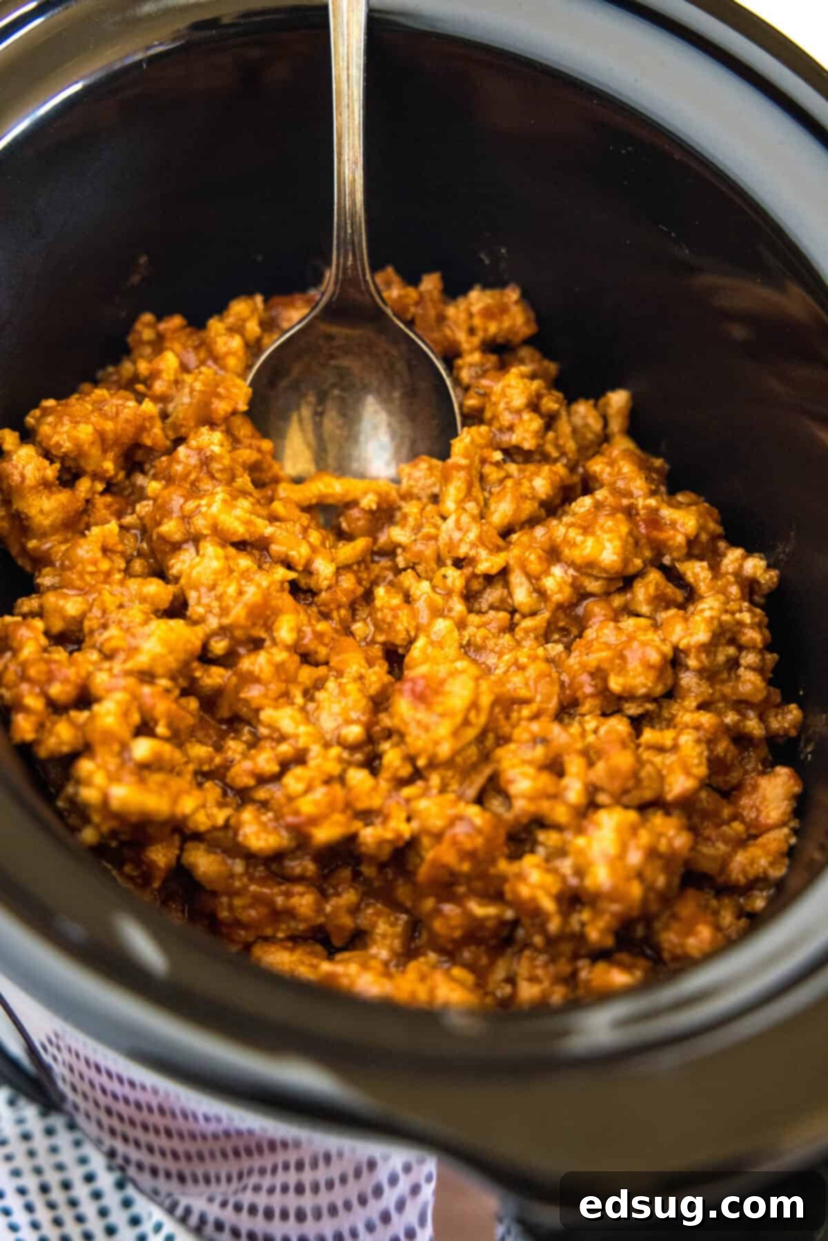 Easy ground turkey Sloppy Joes made with juicy turkey instead of ground beef, cooked in one pan with a rich, flavor-packed homemade sauce! Ground turkey sloppy joe mixture being kept warm inside a slow cooker with a serving spoon.