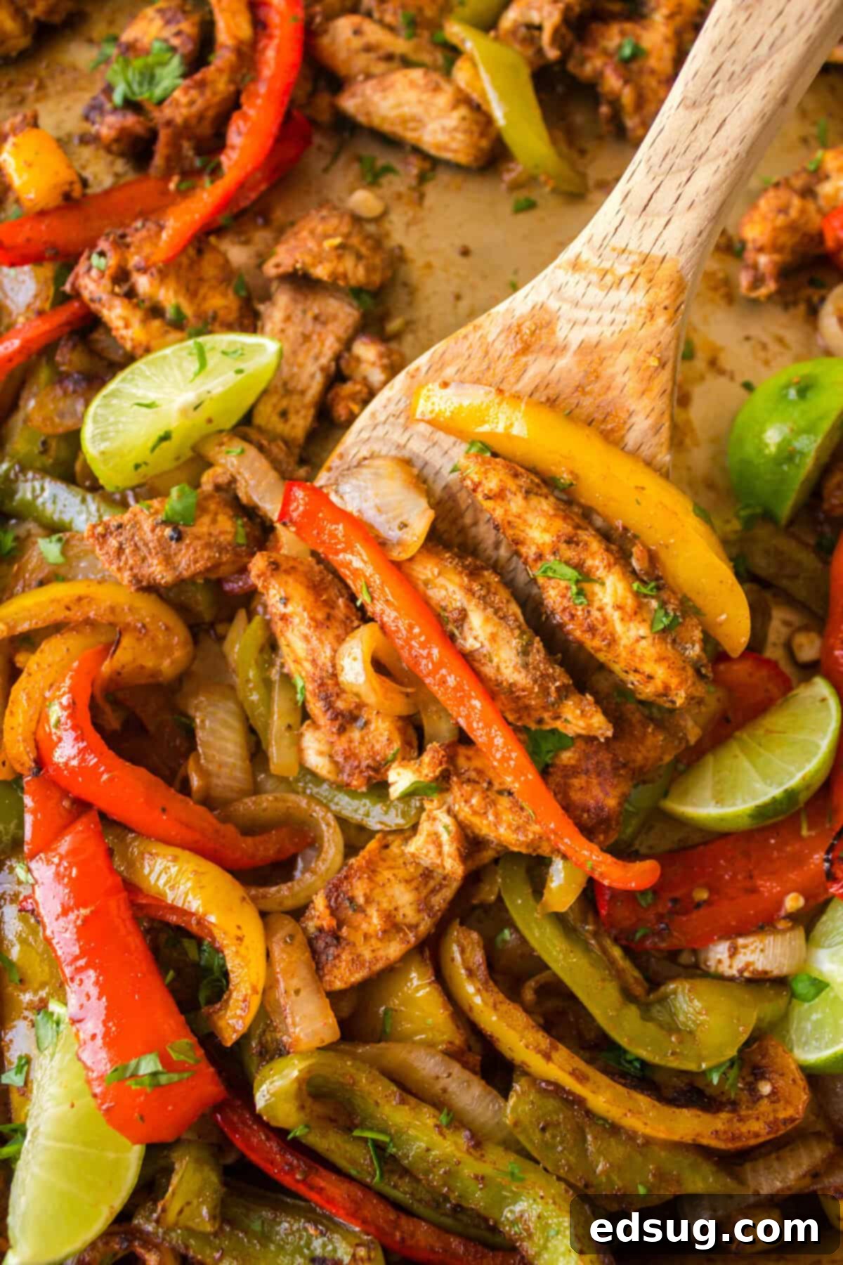 One-Pan Chicken Fajitas 2 scooping chicken fajitas off a sheet pan