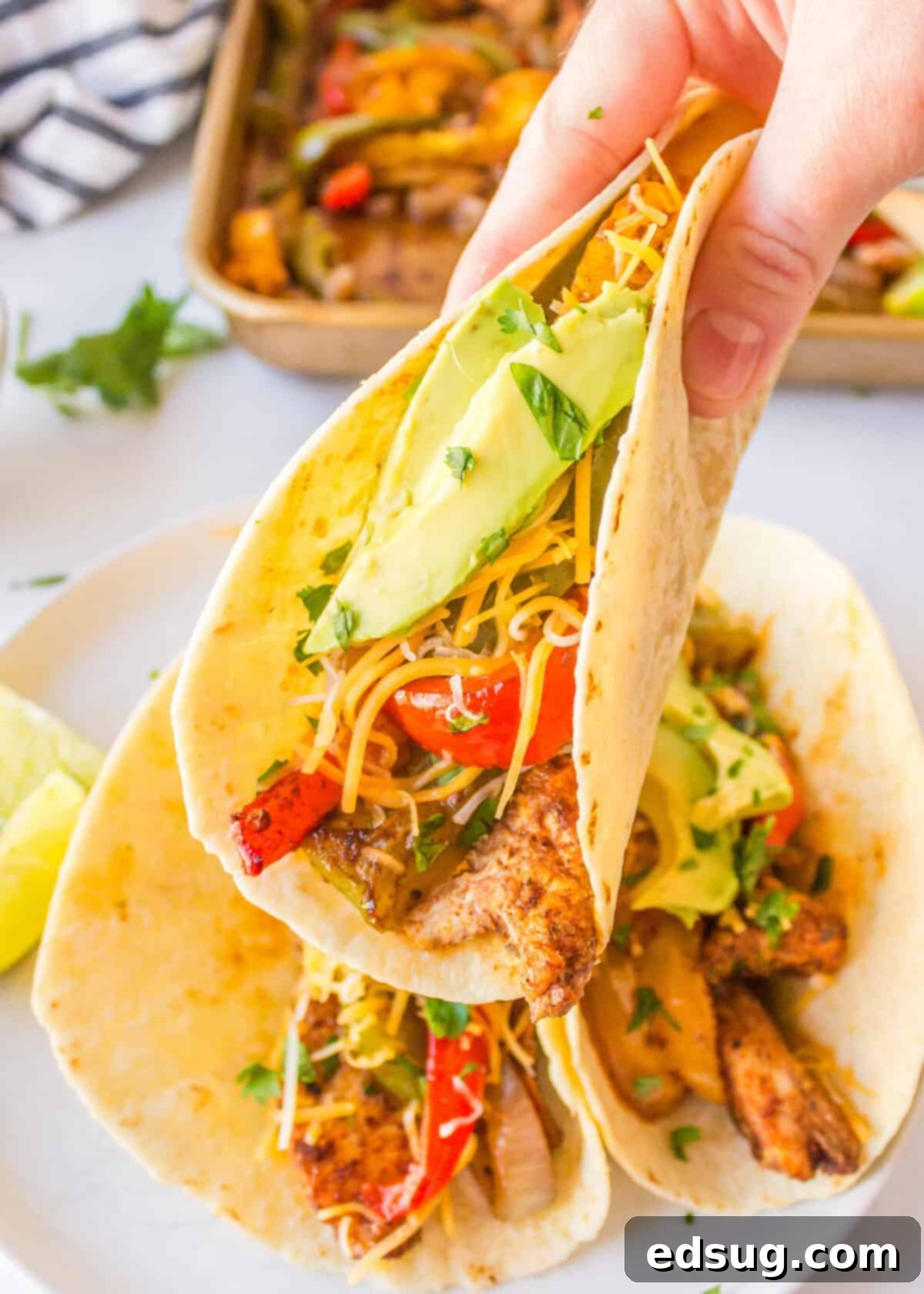 One-Pan Chicken Fajitas 7 lifting up a chicken fajita off a plate