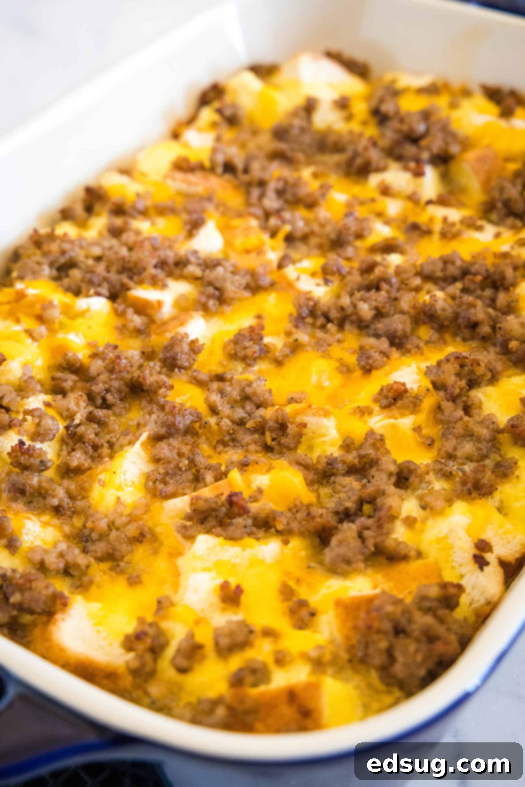 This sourdough breakfast casserole is the ultimate make-ahead breakfast packed with sourdough bread chunks, breakfast sausage, and cheese! A large sourdough breakfast casserole cooling in a glass baking dish, showing its golden-brown top and ready-to-serve appeal.