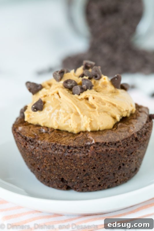 A close up of three finished Peanut Butter Brownie Bites, showing the filled center and chocolate chip topping