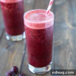 close up cherry almond cocktail in a glass with a cherry garnish
