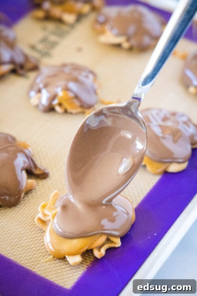spoon melted chocolate over caramel cashew clusters