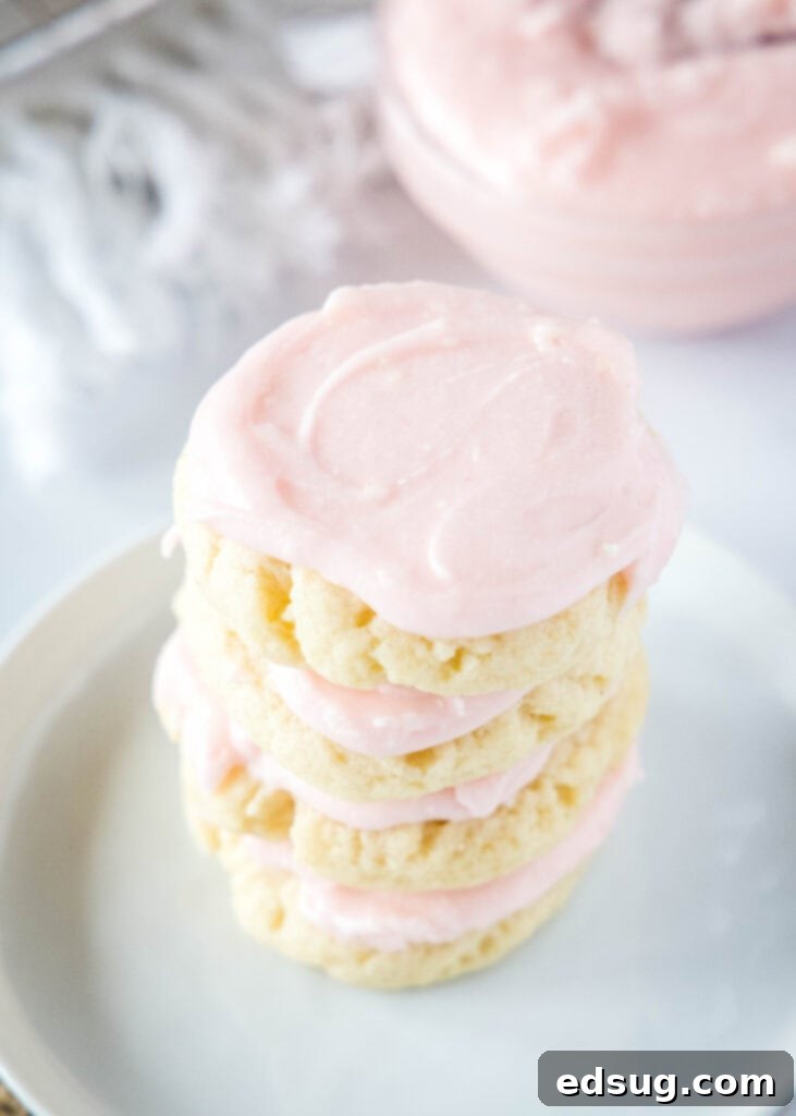 The Quintessential Sugar Cookie 7 A beautiful stack of several frosted sugar cookies on a white plate, ready for serving.