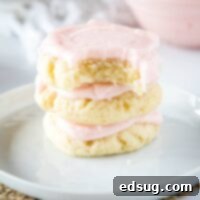 A stack of sugar cookies with a bite taken out of the top one