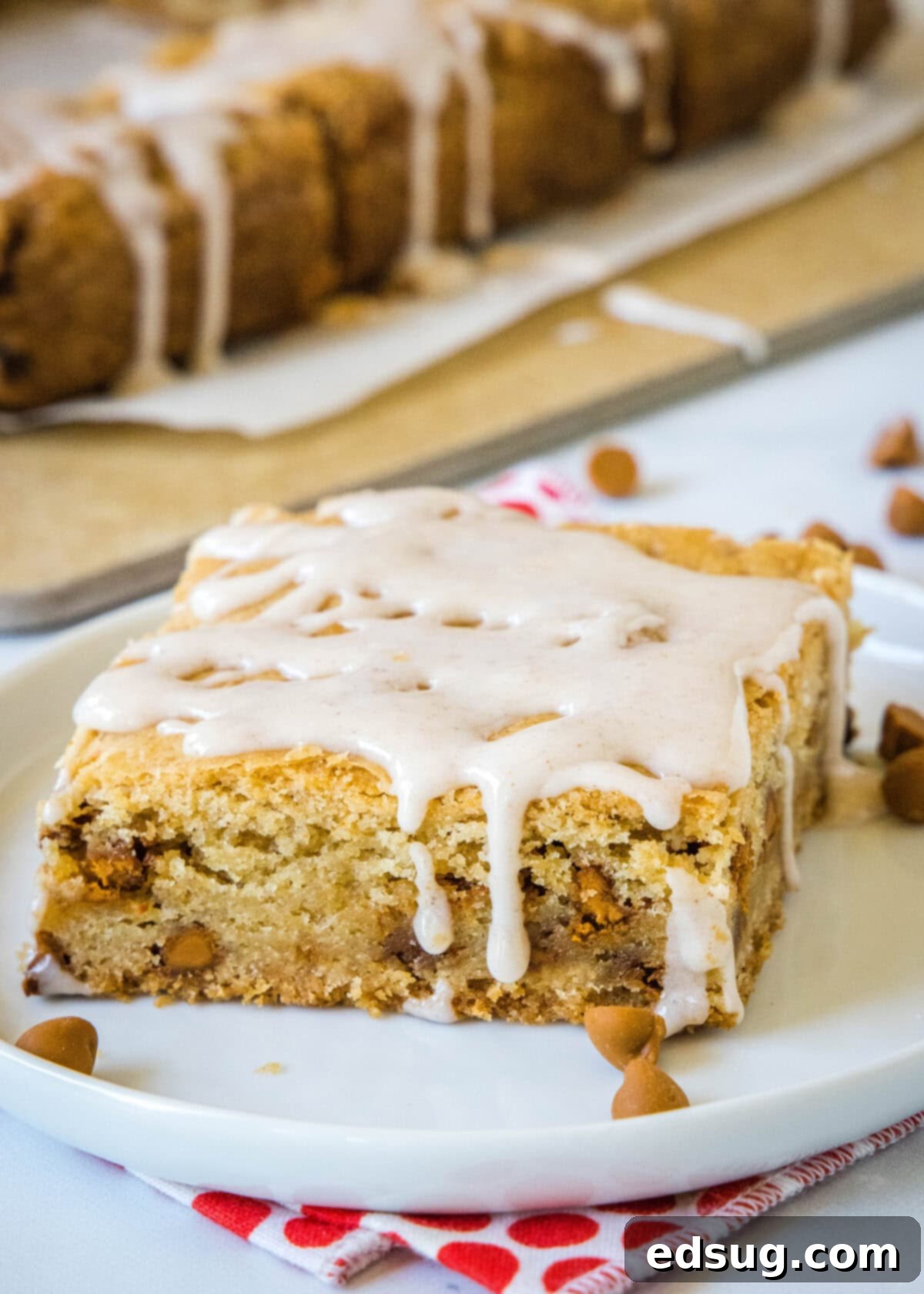 Cozy Cinnamon Blondies 2 A perfectly baked and glazed cinnamon blondie on a rustic serving plate, showcasing its soft texture and cinnamon chips.