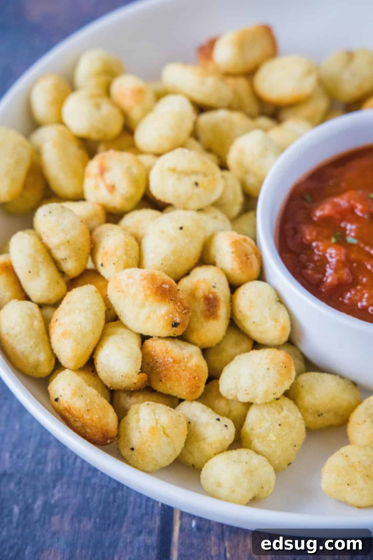 Air Fryer Gnocchi 5 close up air fryer gnocchi on serving platter with bowl of marinara sauce