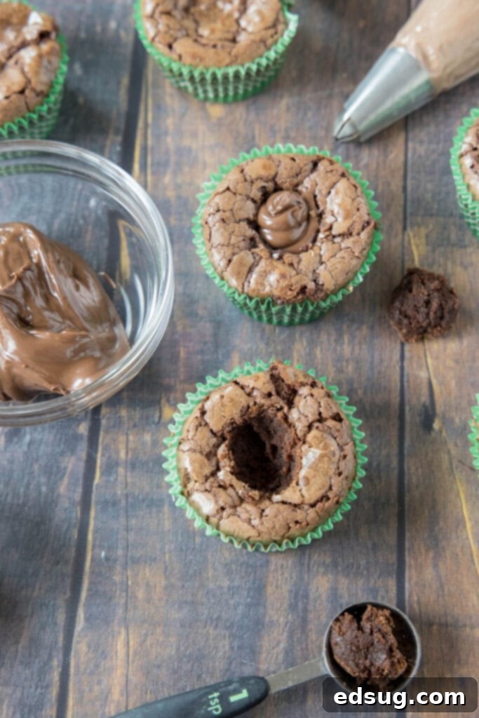 Decadent Nutella Cupcakes 3 Process of carefully filling a hollowed-out chocolate cupcake with smooth Nutella spread