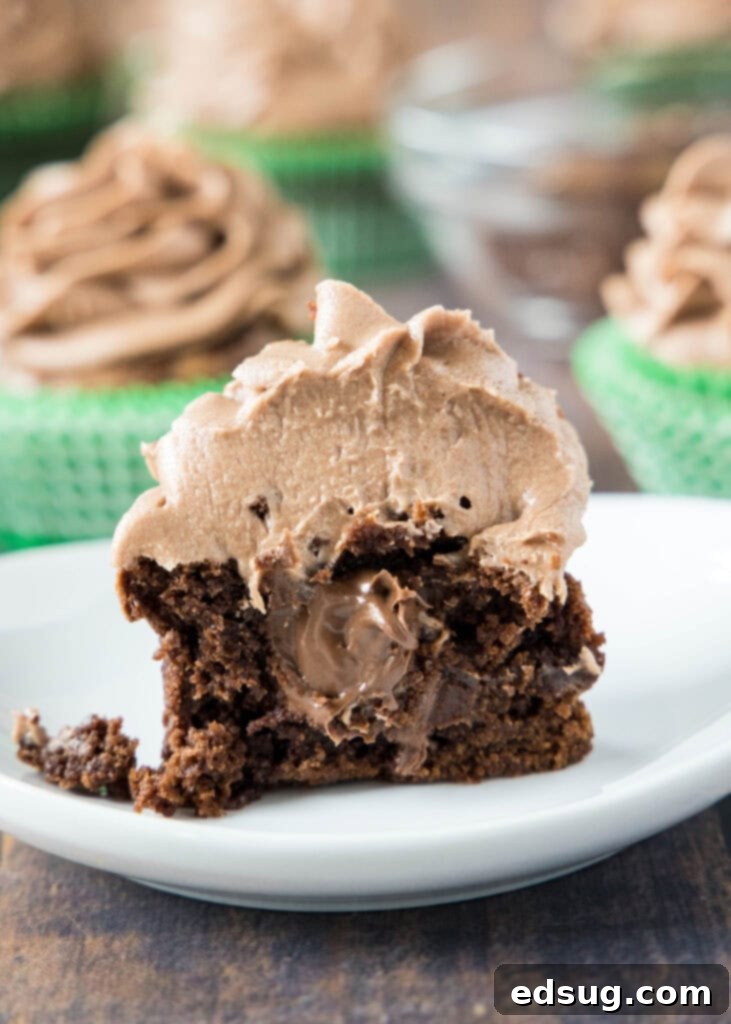 Decadent Nutella Cupcakes 6 Close-up shot of a single Nutella-filled chocolate cupcake on a white plate, showcasing the filling