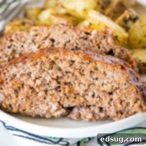 French Onion Meatloaf 2 Onion soup meatloaf slices on a plate with roasted potatoes in the background.