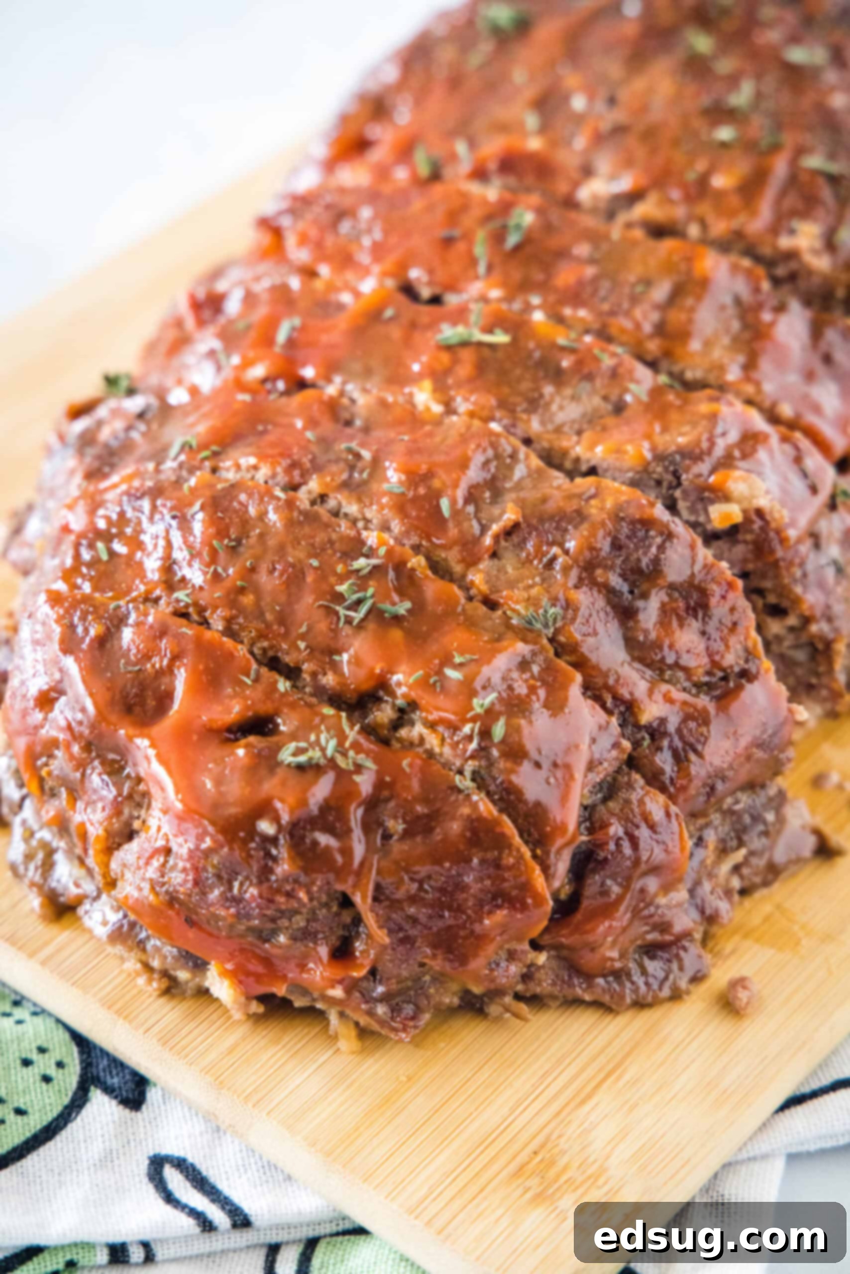 Onion soup meatloaf cut into slices on a wooden cutting board. Onion soup meatloaf cut into slices on a wooden cutting board.