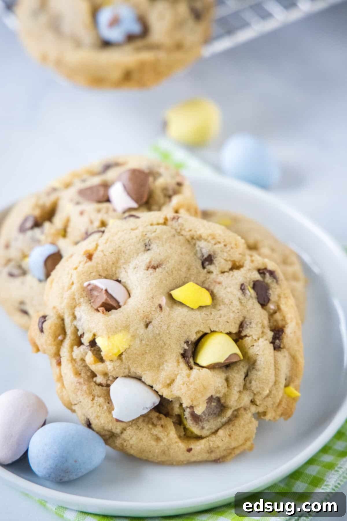 Ultimate Cadbury Mini Egg Cookies 2 cadbury mini egg cookies on a white plate, showcasing their vibrant colors and chewy texture