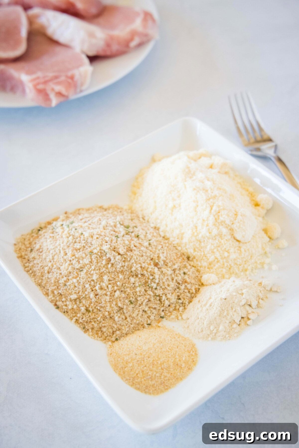 Bowl with Italian breadcrumbs, Parmesan cheese, garlic powder, and onion powder for pork chop coating.