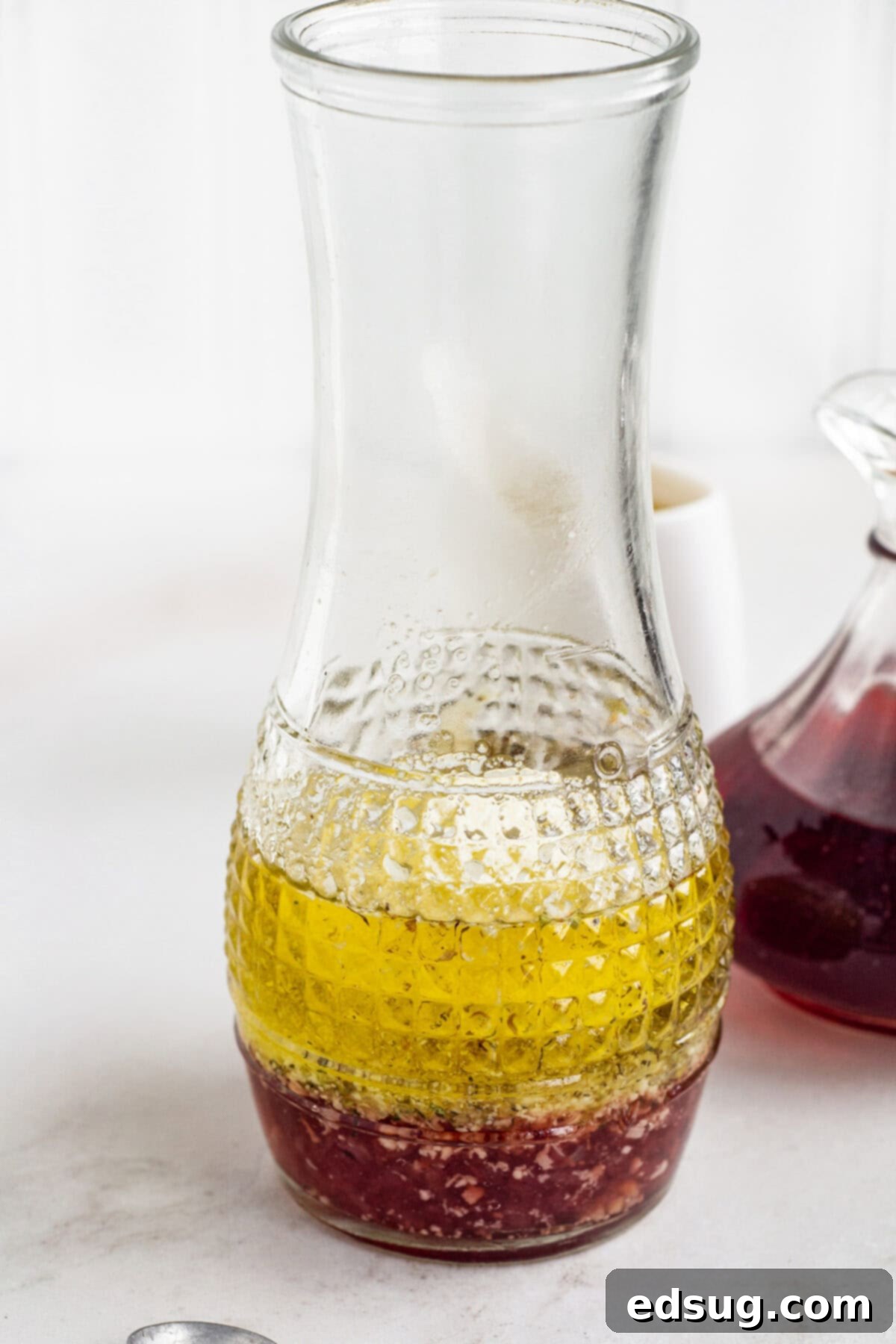 All the dry and wet ingredients for red wine vinaigrette combined in a glass jar, ready for mixing.