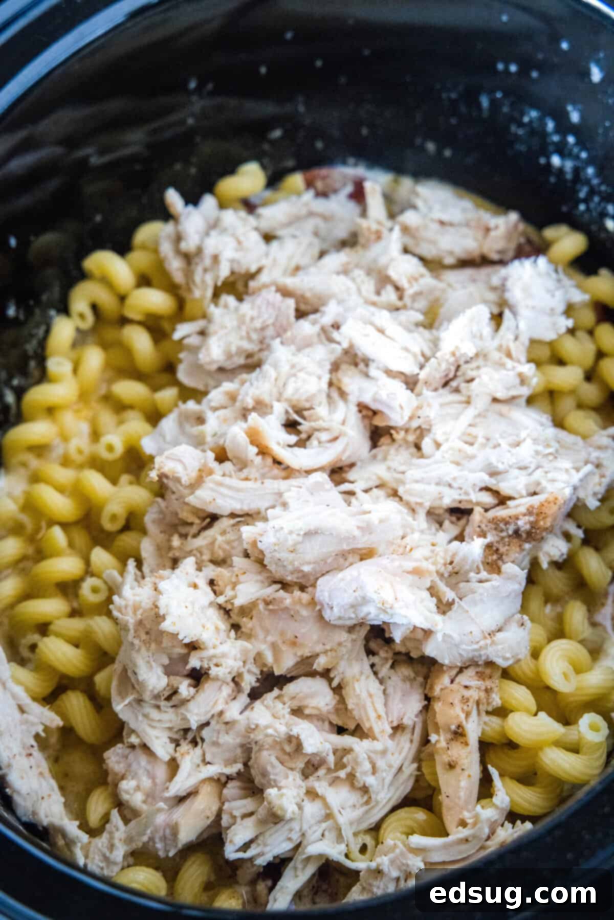 This creamy crockpot Cajun chicken pasta is easy to make in the slow cooker with spicy sausage and a rich, cheesy sauce. Just add pasta! Shredded Cajun chicken and cooked pasta mixed into the creamy sauce in the slow cooker.