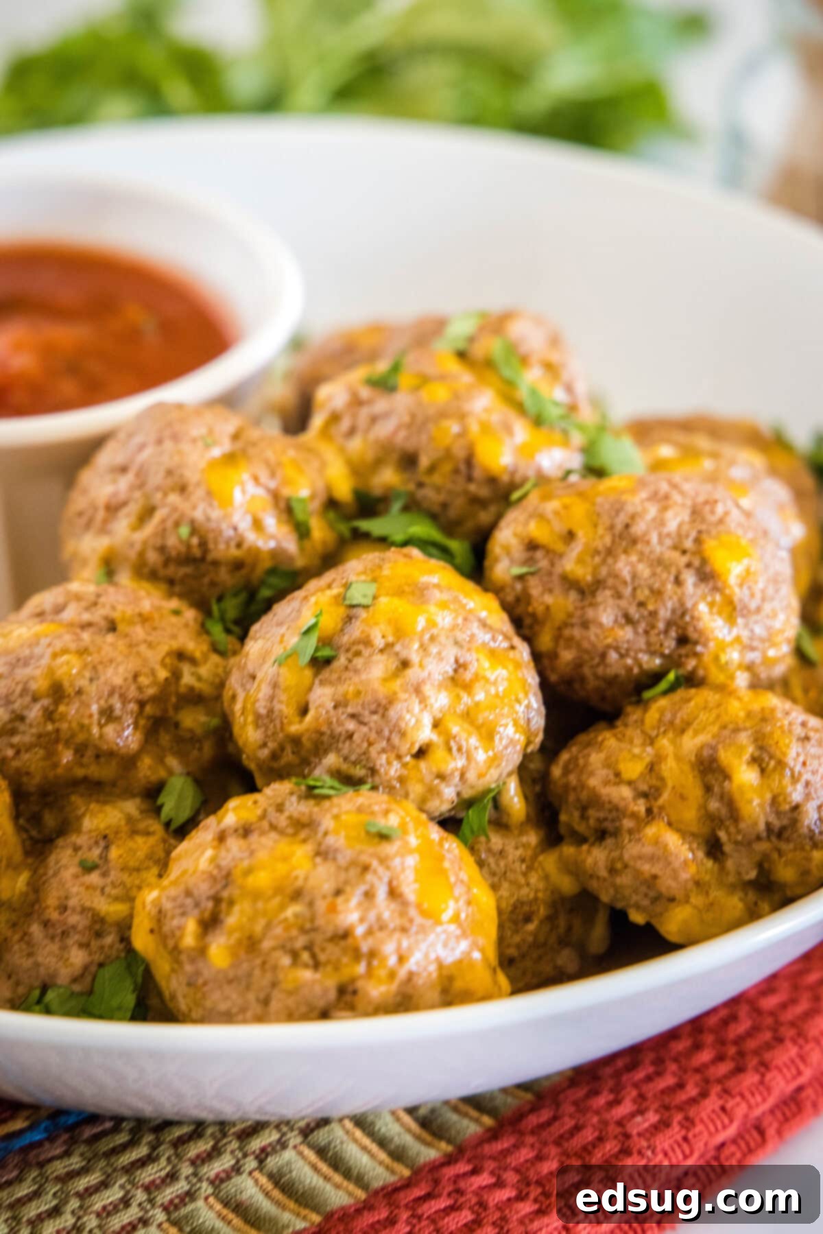 taco meatballs on a white serving plate with a dish o salsa