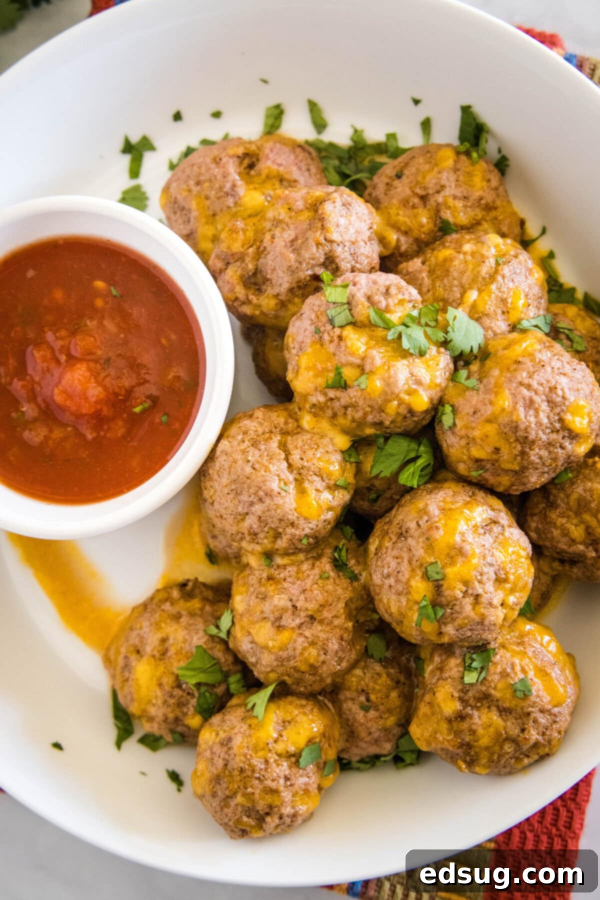 looking down on a plate with taco meatballs and a dish of salsa