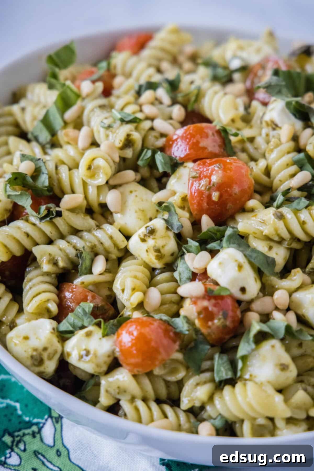 a serving bowl with creamy pesto pasta salad