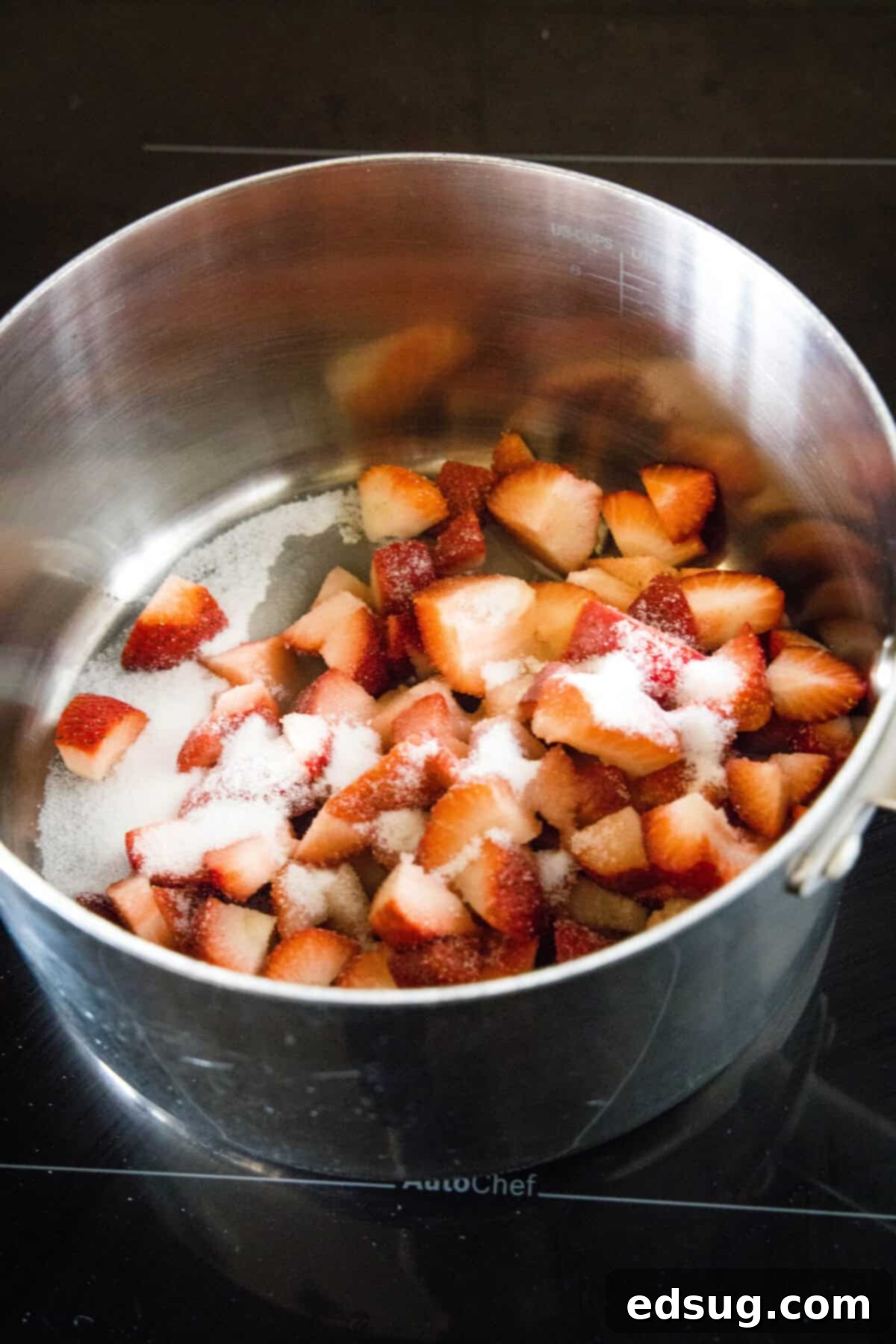 These strawberry cheesecake bars have a tangy cream cheese filling swirled with gooey strawberries, baked on top of a graham cracker crust. Chopped strawberries and sugar combined in a saucepan.