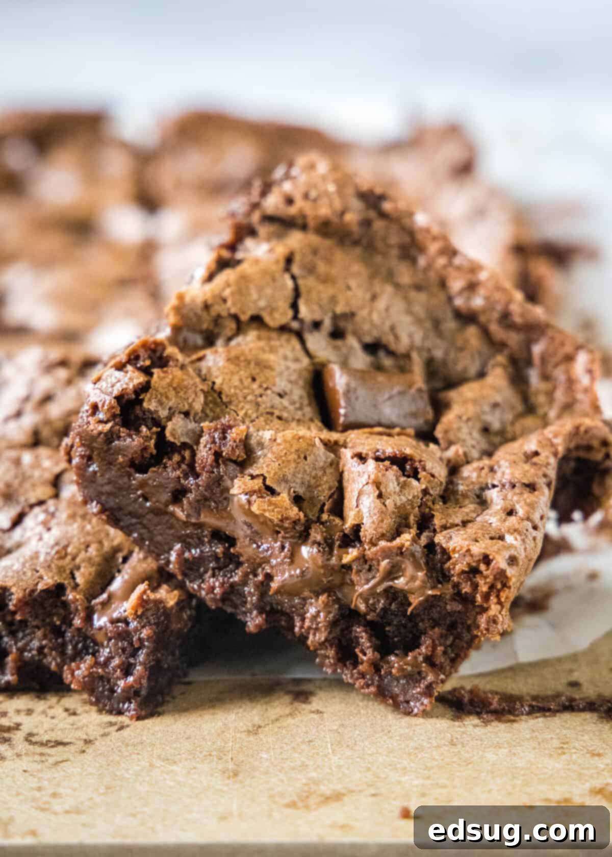 Decadent Chocolate Chunk Brownies 7 A single fudgy chocolate chunk brownie placed on a wooden cutting board, highlighting its rich color and generous chocolate pieces.