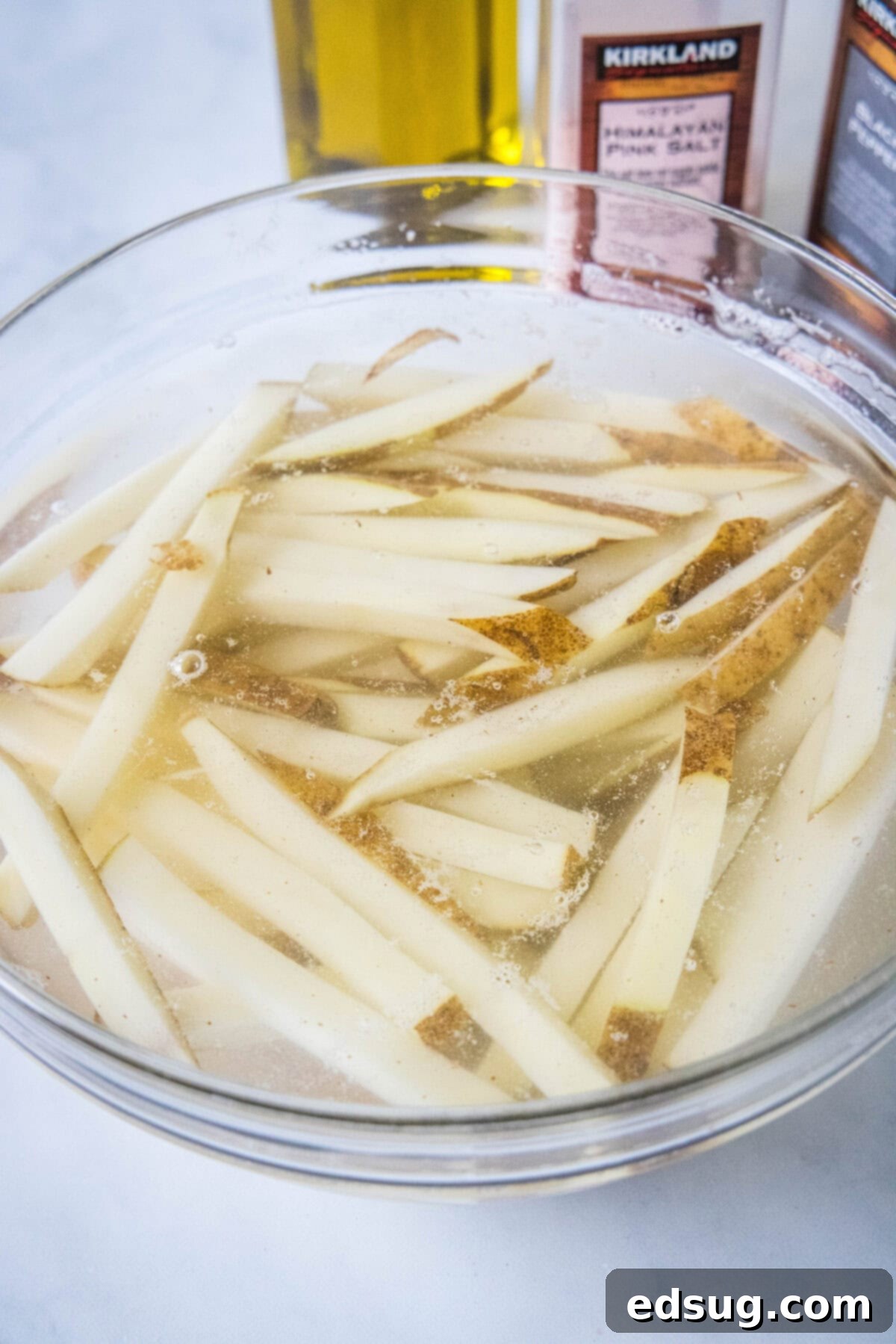 Homemade air fryer French fries are just as crispy as regular fries! Make them in a fraction of the time, with any seasonings you’d like. Cut French fries soaking in a bowl of water.