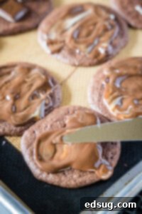spreading melted candy over chocolate cookies