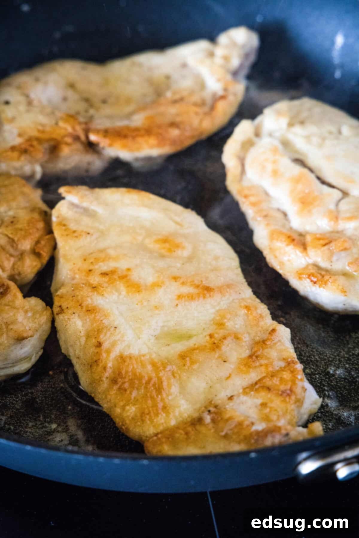Pan-seared chicken in a skillet.
