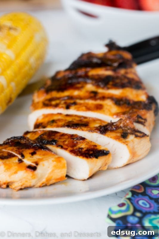Perfectly grilled chicken slices served on a plate alongside a corn on the cob, inviting a taste of summer.