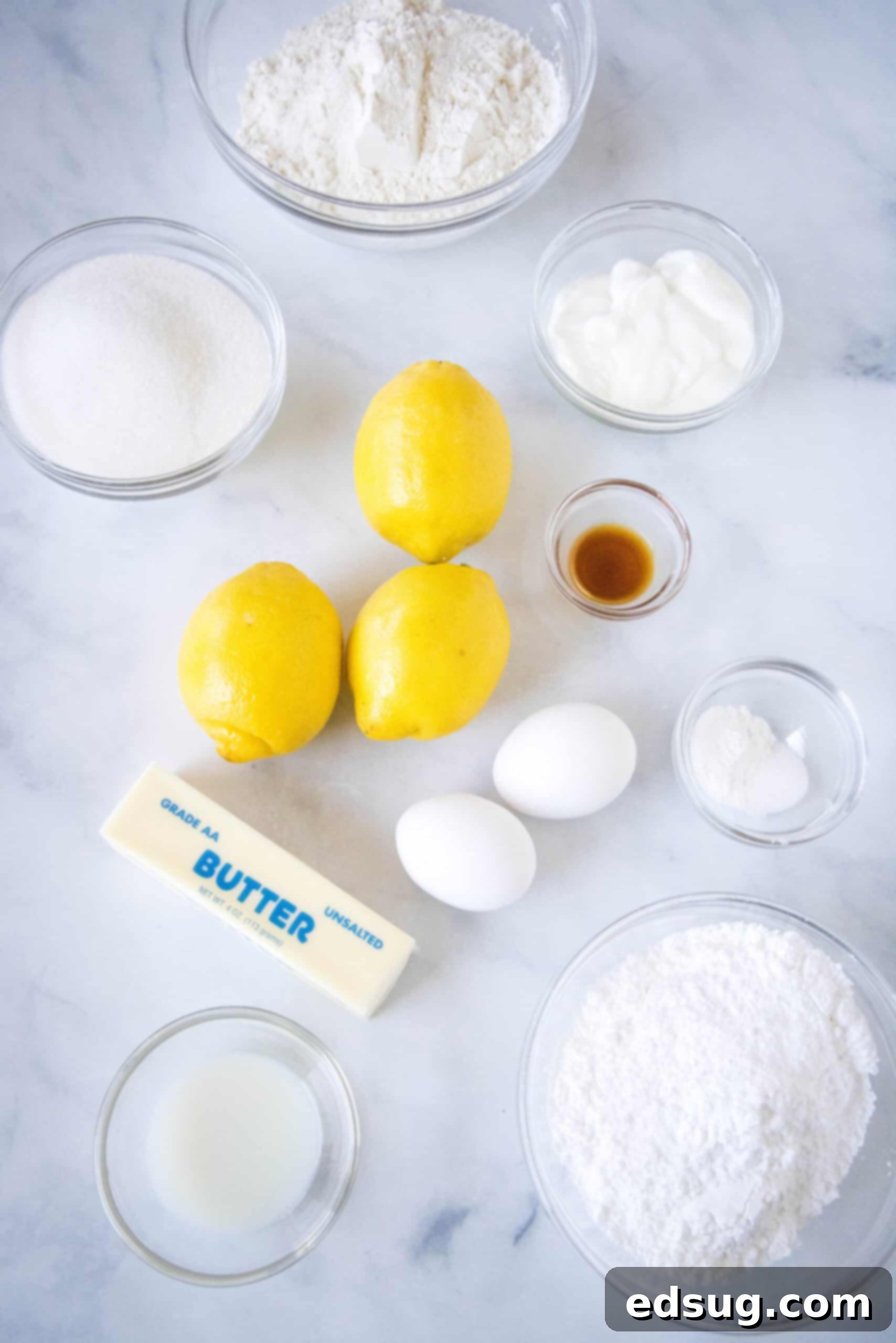 Close-up of fresh lemon loaf ingredients on a rustic wooden table.