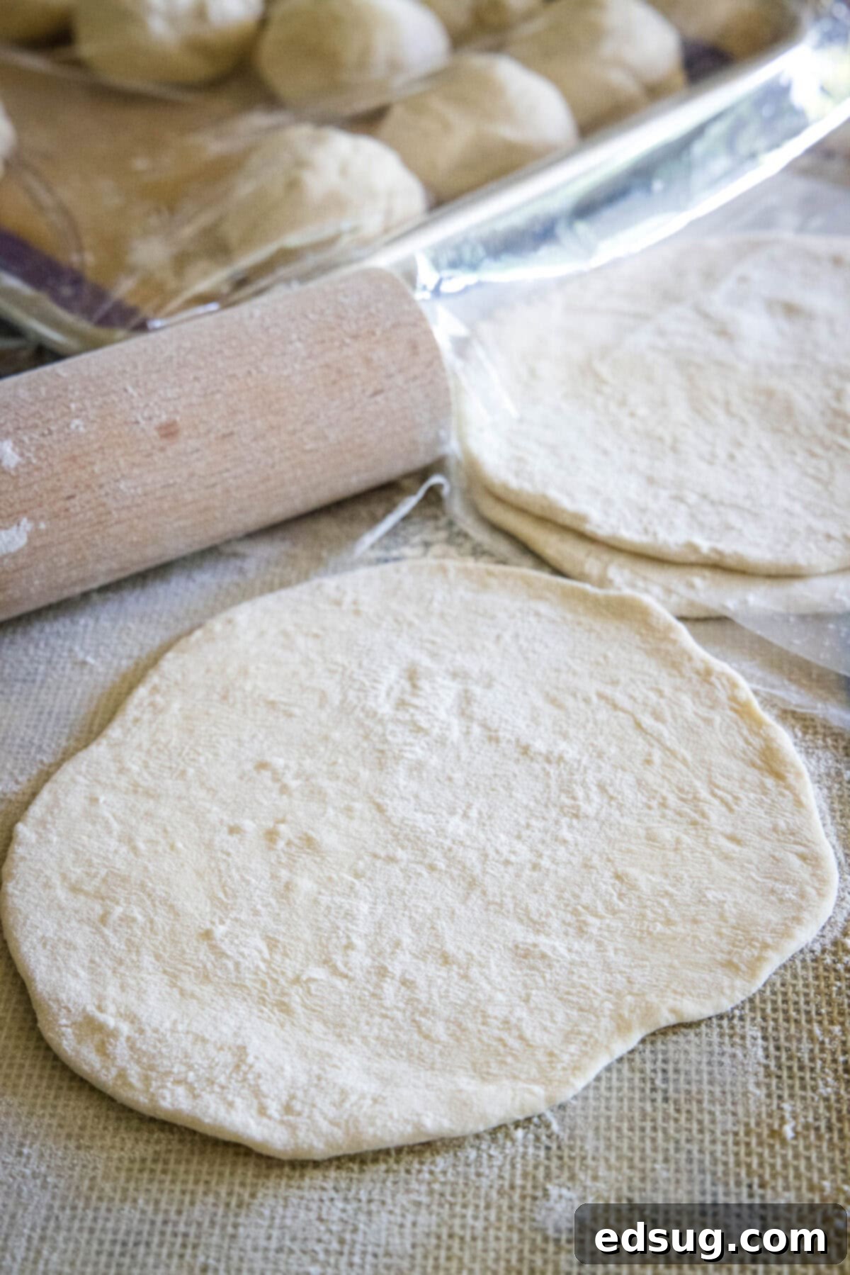 Navajo Fry Bread Tacos 7 A rolling pin flattening a ball of fry bread dough into a disk on a floured surface.