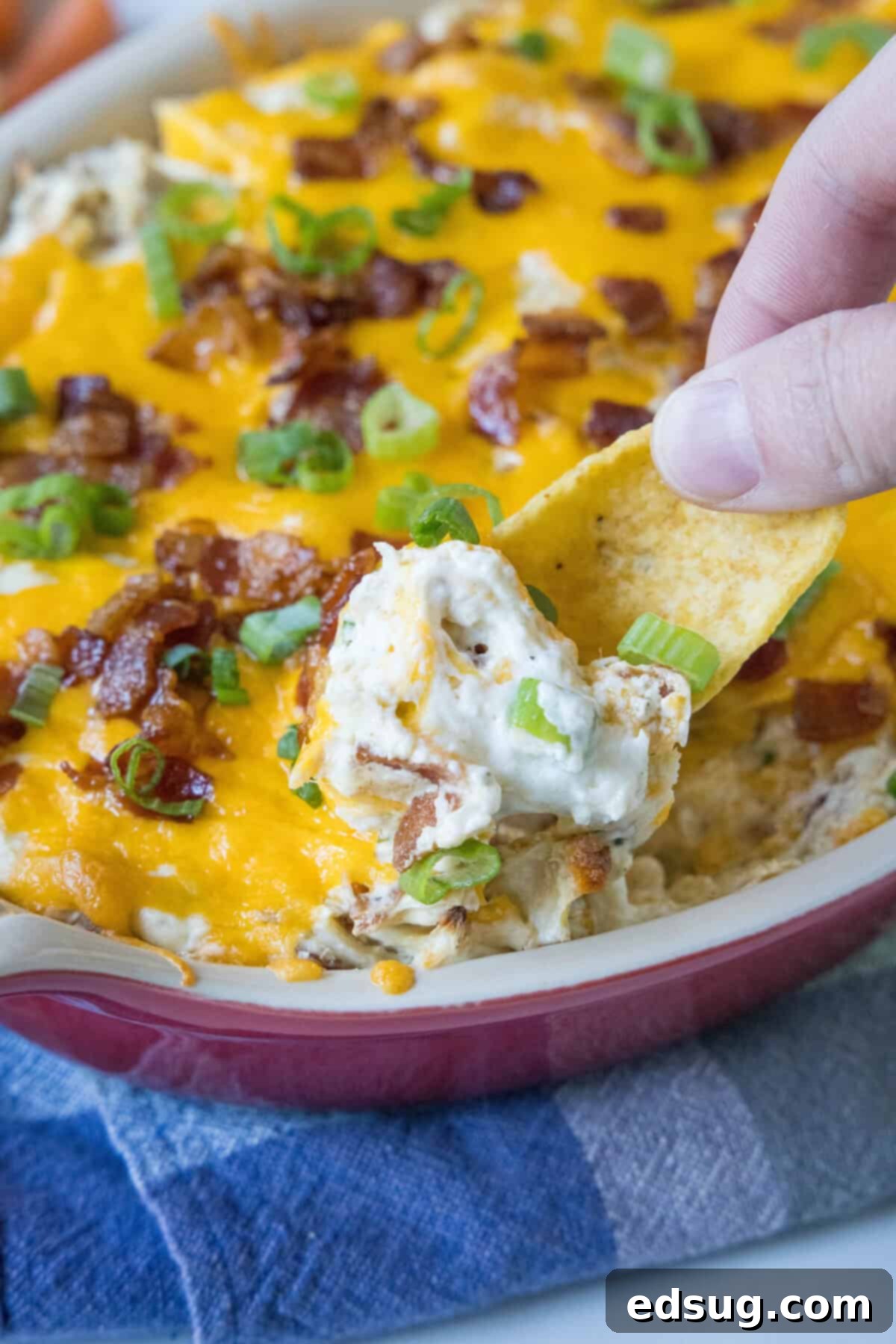 scooping chicken bacon ranch dip out of baking dish
