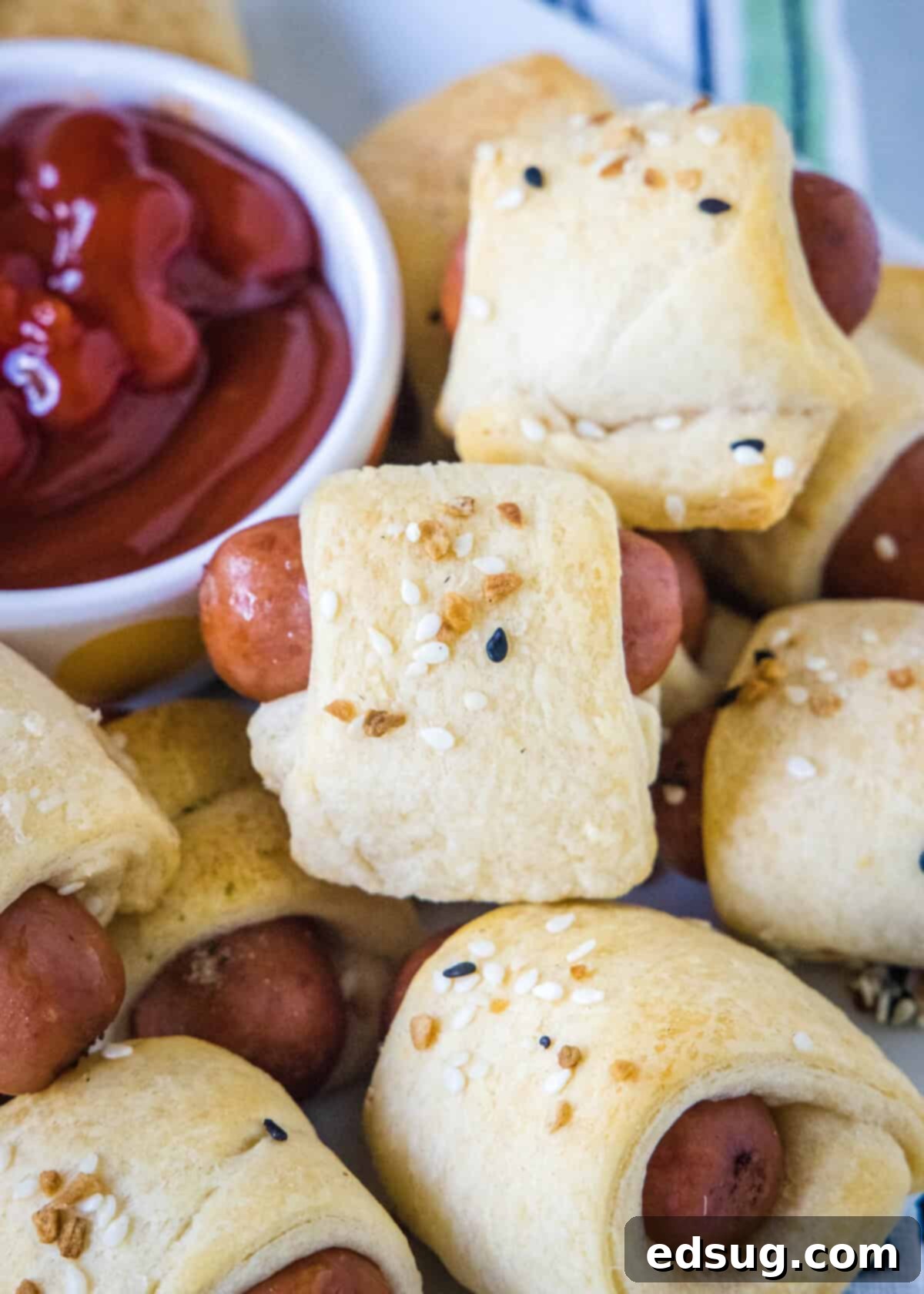 pigs in a blanket on a serving platter with ketchup