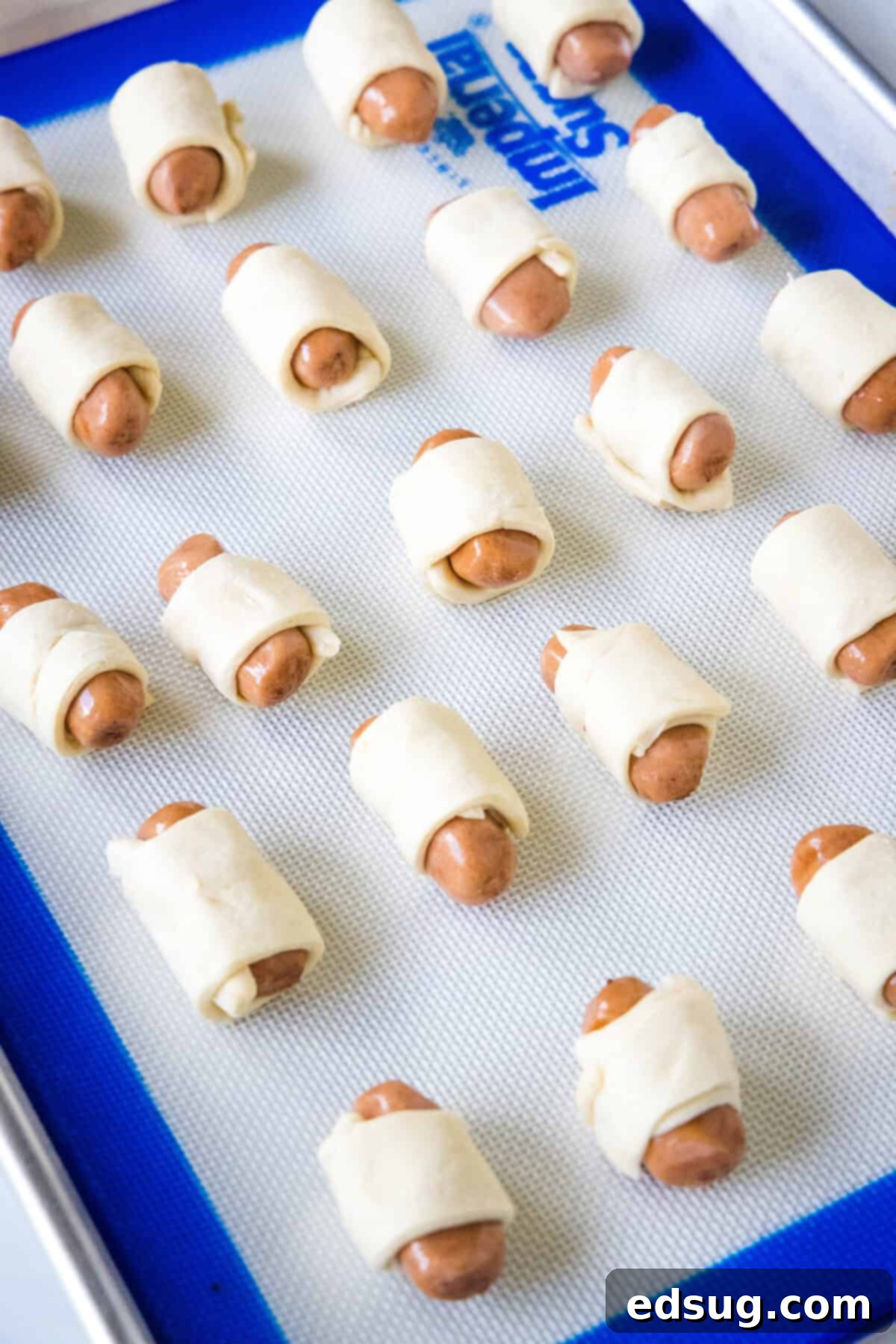 pigs in a blanket on baking sheet ready for the oven